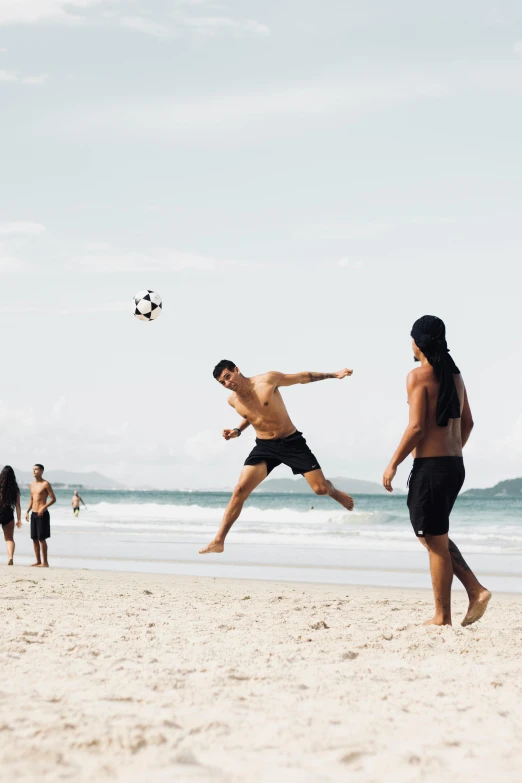 man leaping into the air with his back to the other man as he catches a frisbee