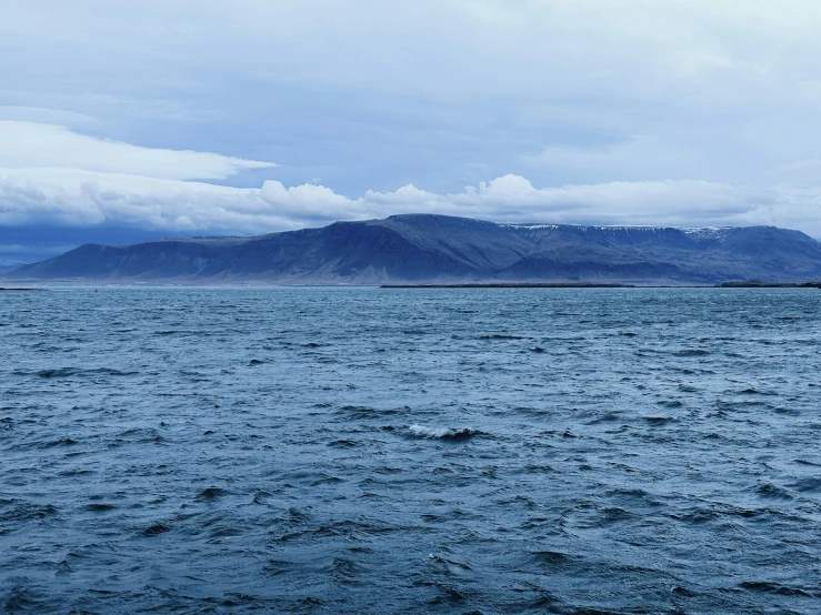 an open water body of water with a mountain in the background