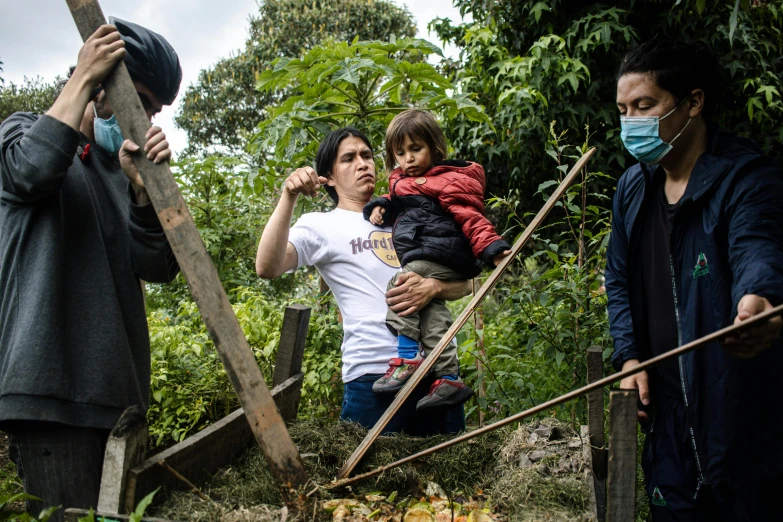 three people wearing face masks stand on a path