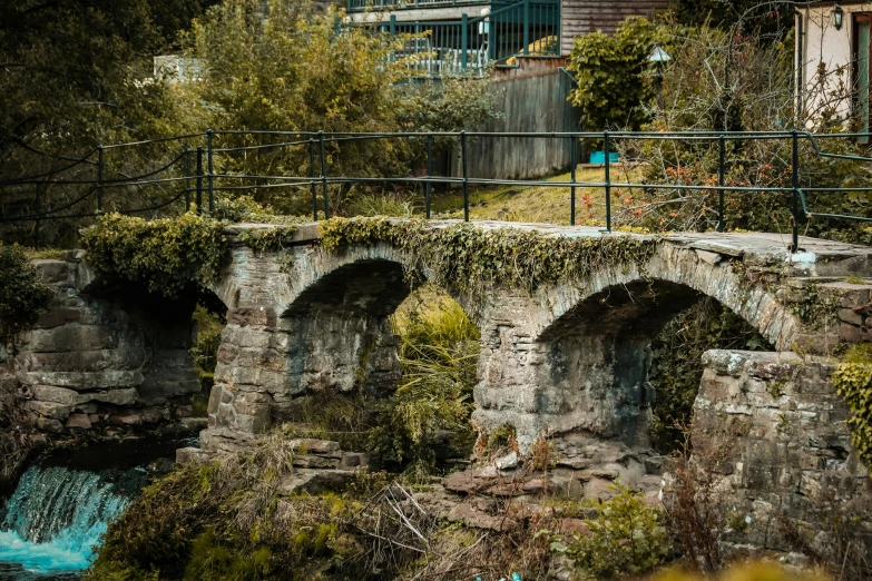 an old stone bridge with ivy growing over the top