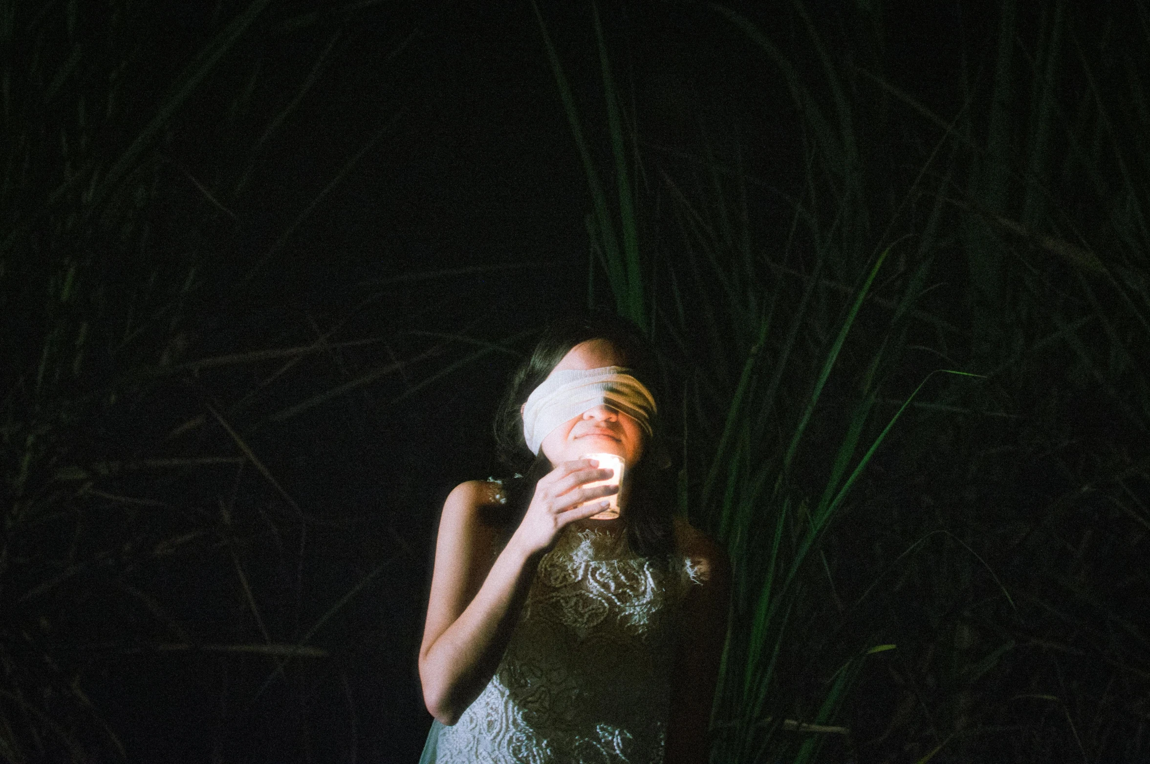 woman in dress drinking from her mug in the dark