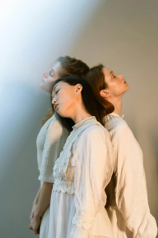 a woman standing next to a man while they both wear white dresses