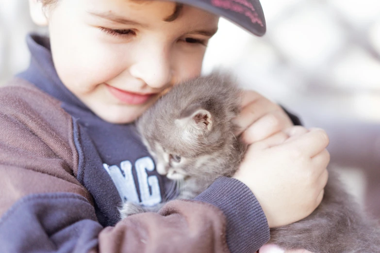  holding kitten while smiling at camera