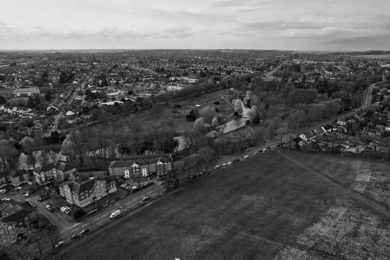 an aerial view of a field, city and buildings in the background