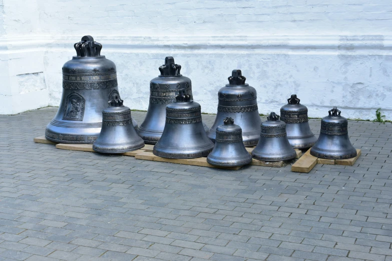 a group of bells sitting in front of a white building