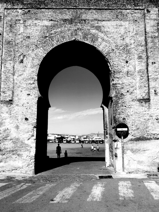 two people standing under an archway near a street