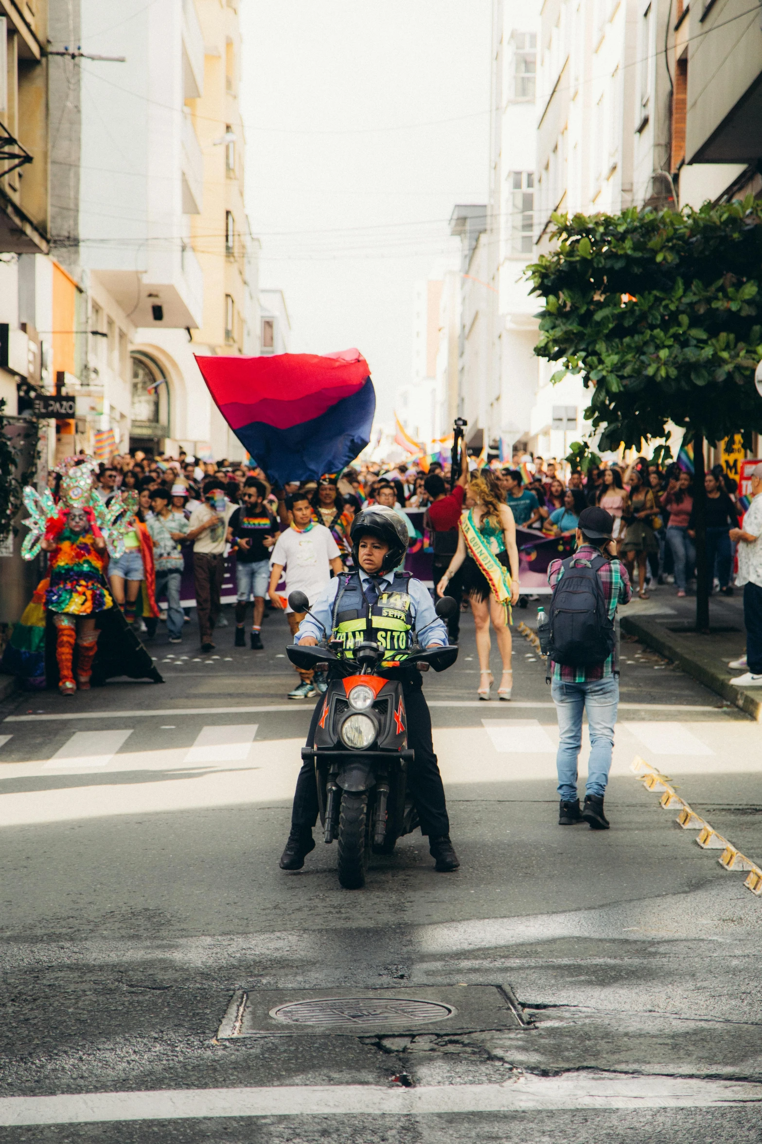 a crowd of people are gathered in the street near a motorcycle