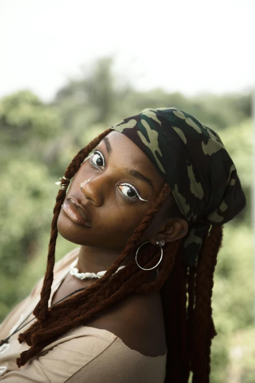 a young black woman with dreadlocks looks away from the camera
