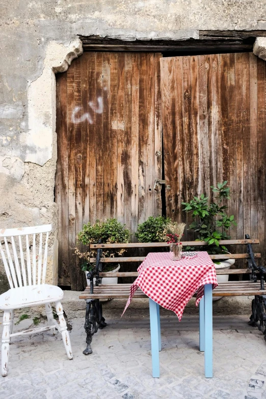 the bench is made of wood with a checkered cloth on it