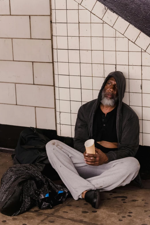 a man is sitting on the ground holding an object