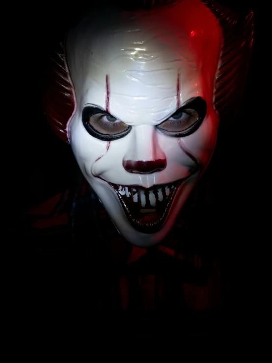 a creepy clown in the dark with glowing eyes
