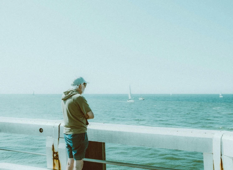 man standing on the deck of a boat with a large ocean behind him