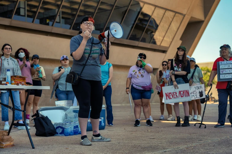 woman holding up a sign and a megaphone