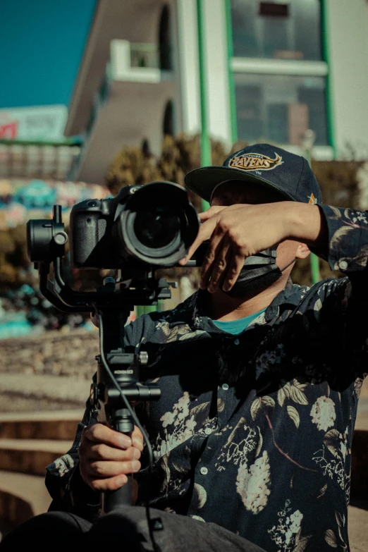 a man that is holding a camera with a lens