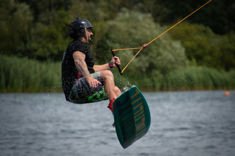 a man in a helmet wake boarding on water