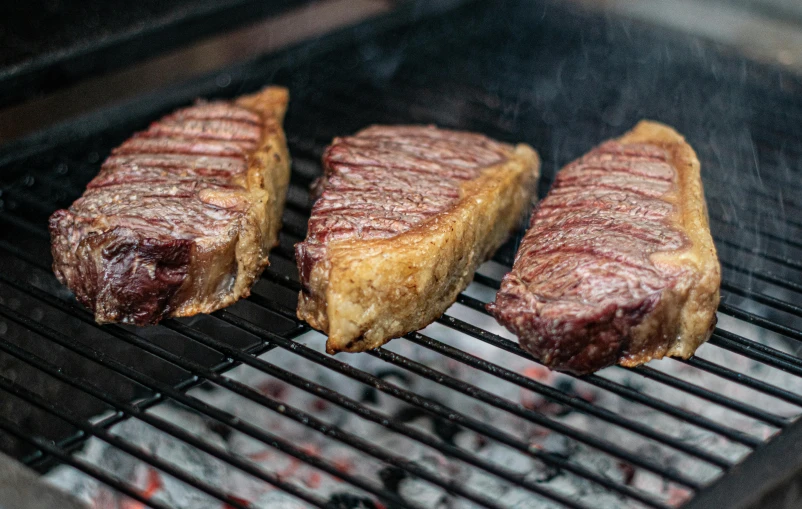 steaks on a grill with no flames are ready to be cooked