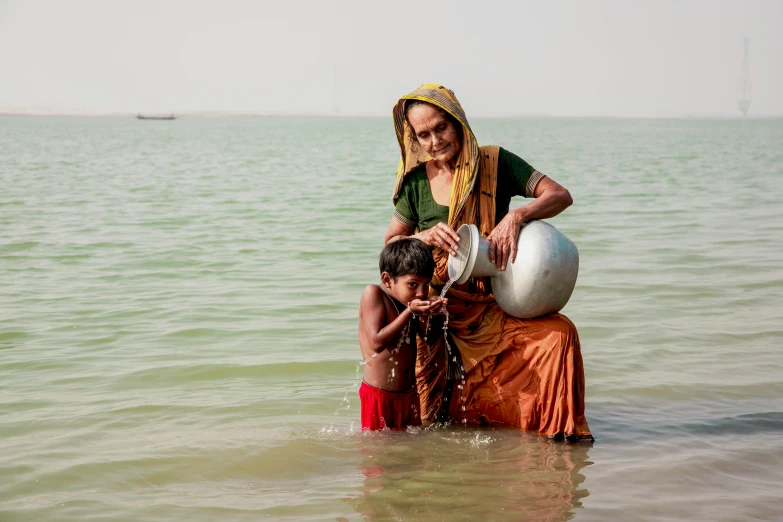 woman with a young child in the water on her back