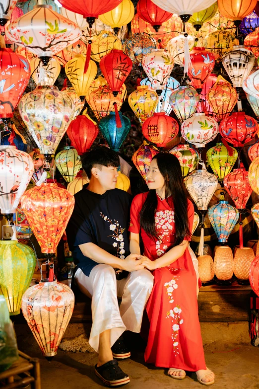 a couple in front of many lanterns with colorful colors