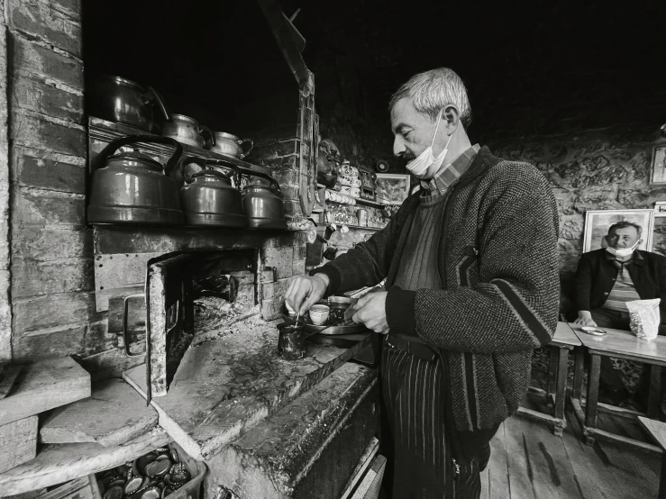 an older woman cooks food in a kitchen