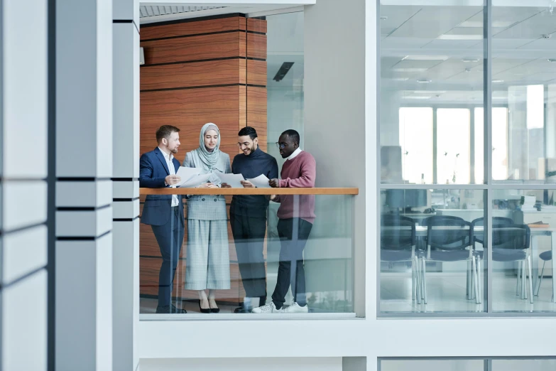 four people with papers in hand looking at them