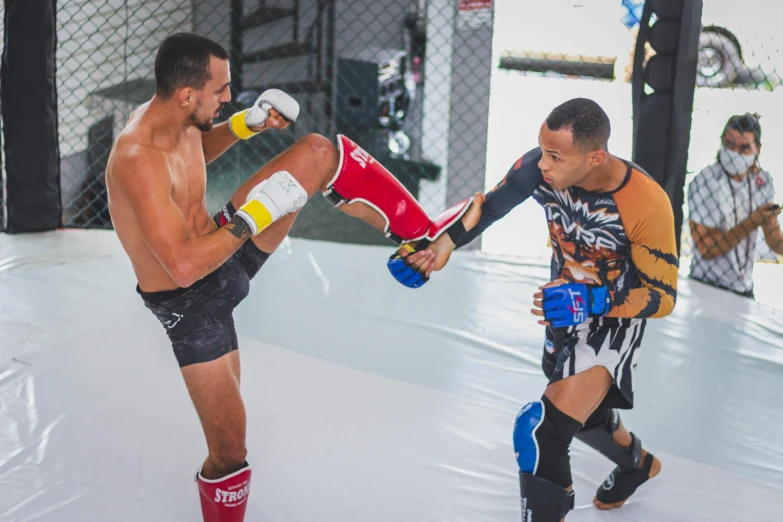 a man kicking another man with boxing gear