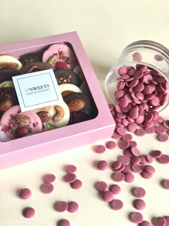 the pink box contains chocolate candies, and a jar