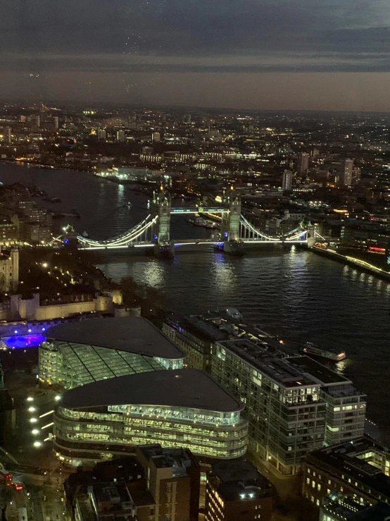 the london skyline lit up in blue, green, and purple