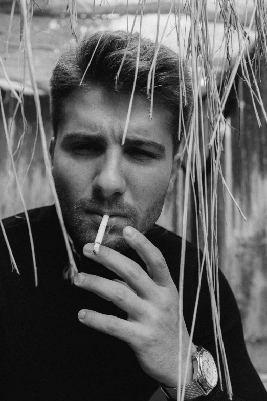 black and white pograph of a man smoking a cigarette