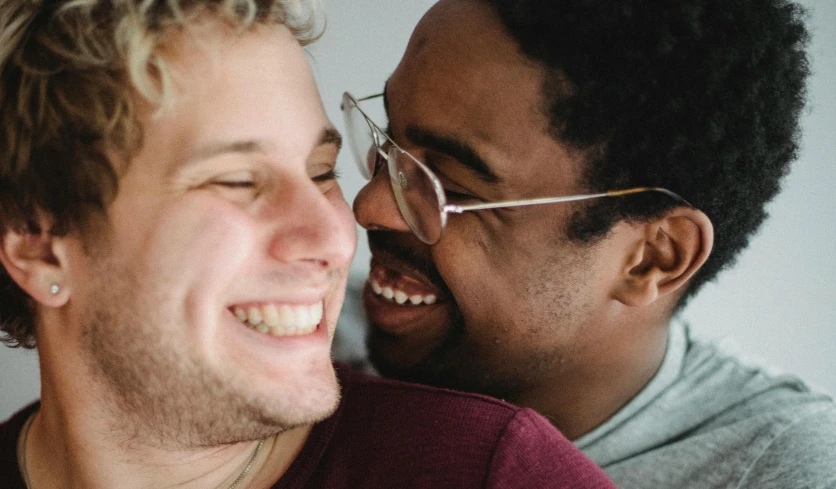 two men laugh together while they are holding soing