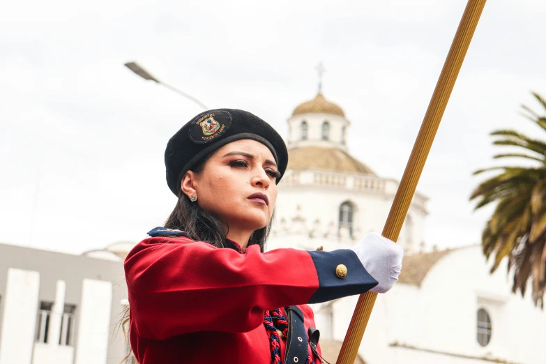 a woman dressed in red is holding a pole