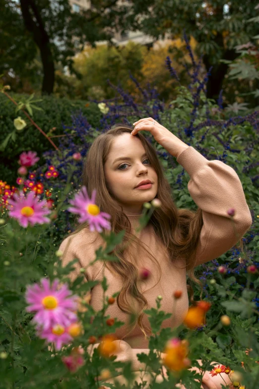 a woman sitting in the middle of a field of flowers