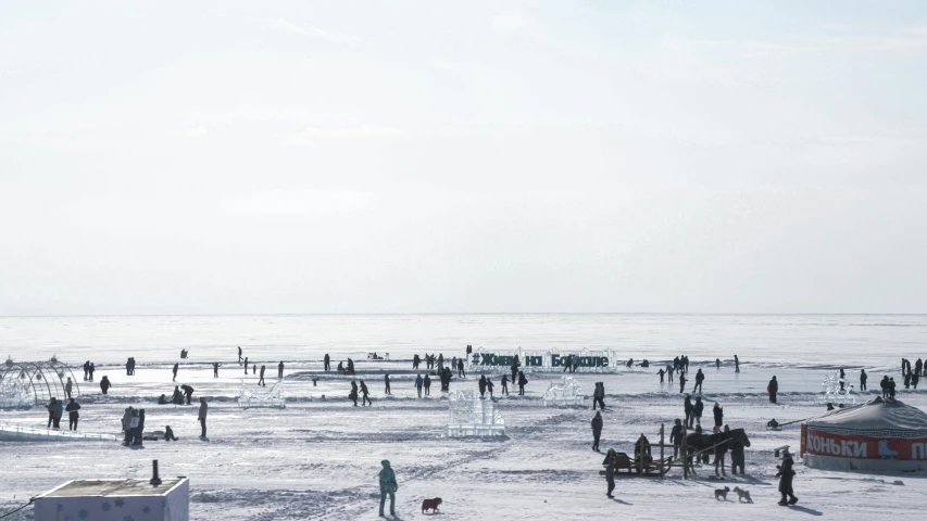 a beach with a lot of people and a boat at the shore