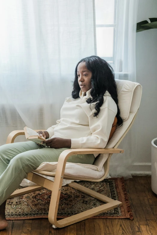 an old woman sitting in a rocking chair holding a remote