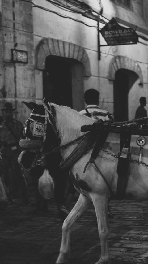 a horse being led down a city street by men in uniform