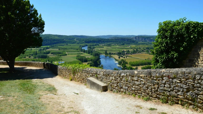 a stone wall overlooks a valley in the distance