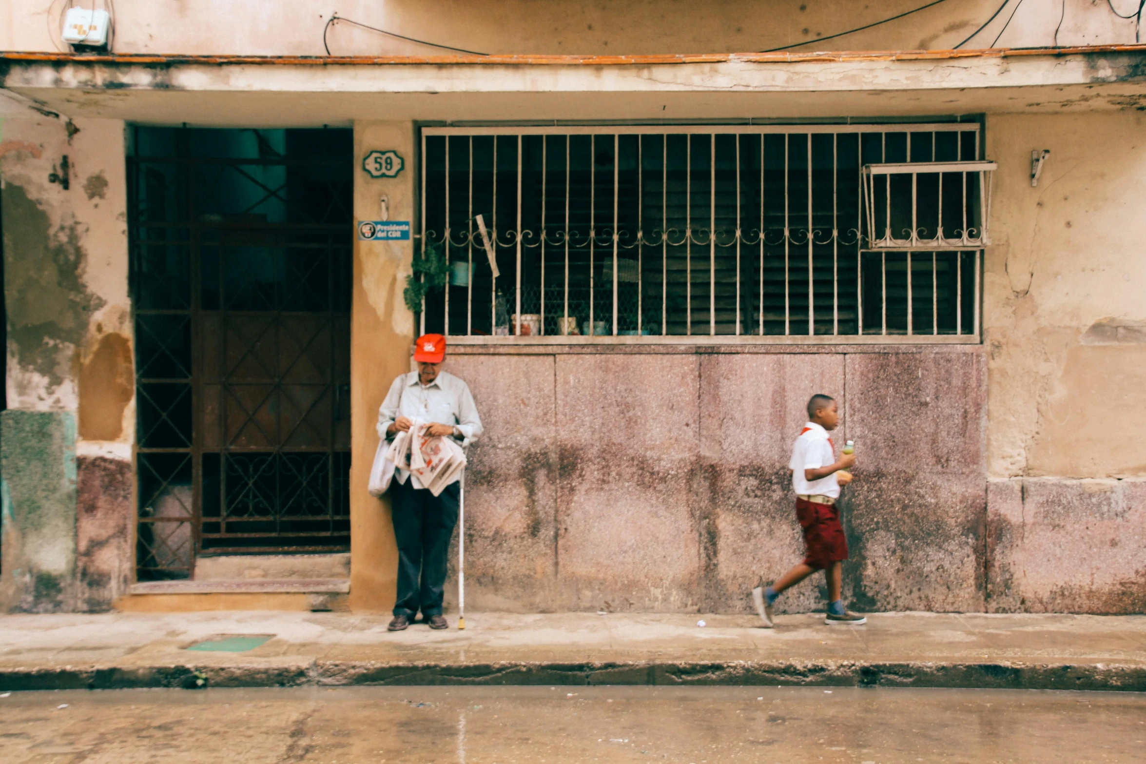 two older people standing outside a brick building