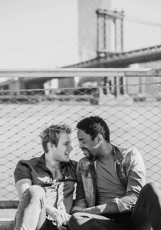 two young men are sitting on the street