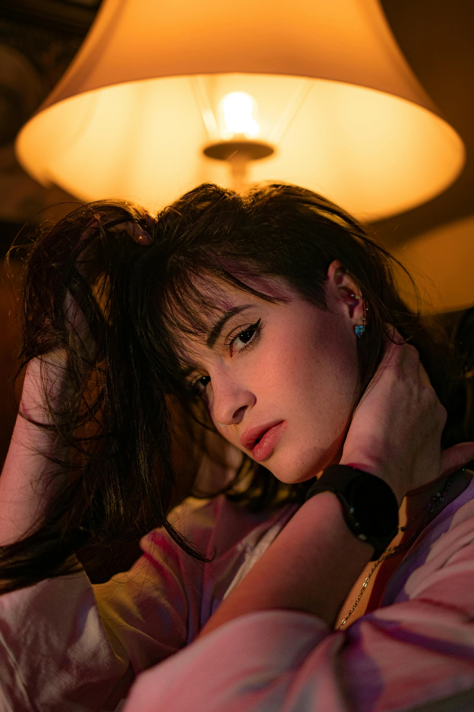 a girl resting her head on her hands in a dimly lit room