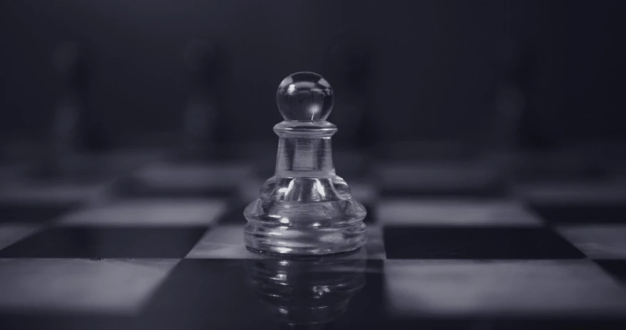 a glass chess set is standing on a black and white chess board