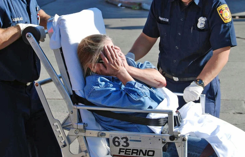 a person in a hospital chair covering her face