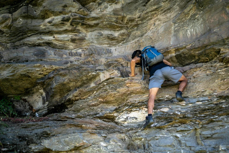 a man with a backpack climbing up a hill
