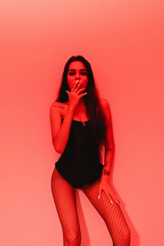 a woman in black outfit smoking cigarette in red background