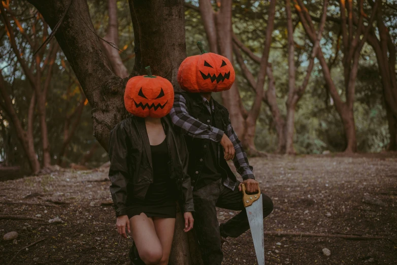 two people are walking with faces made of pumpkin hats