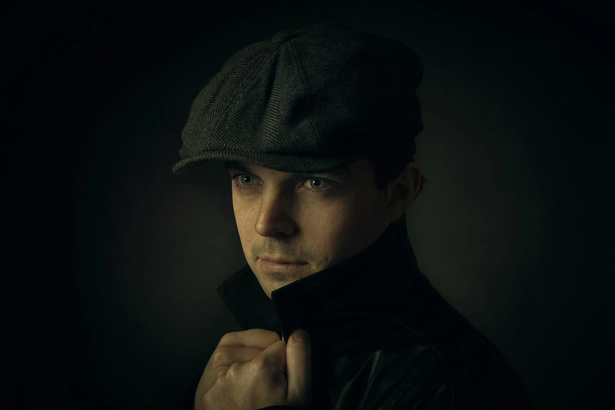 a man with an elegant hat on in the dark