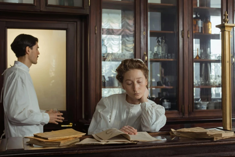 a lady sits at a desk and studies a document