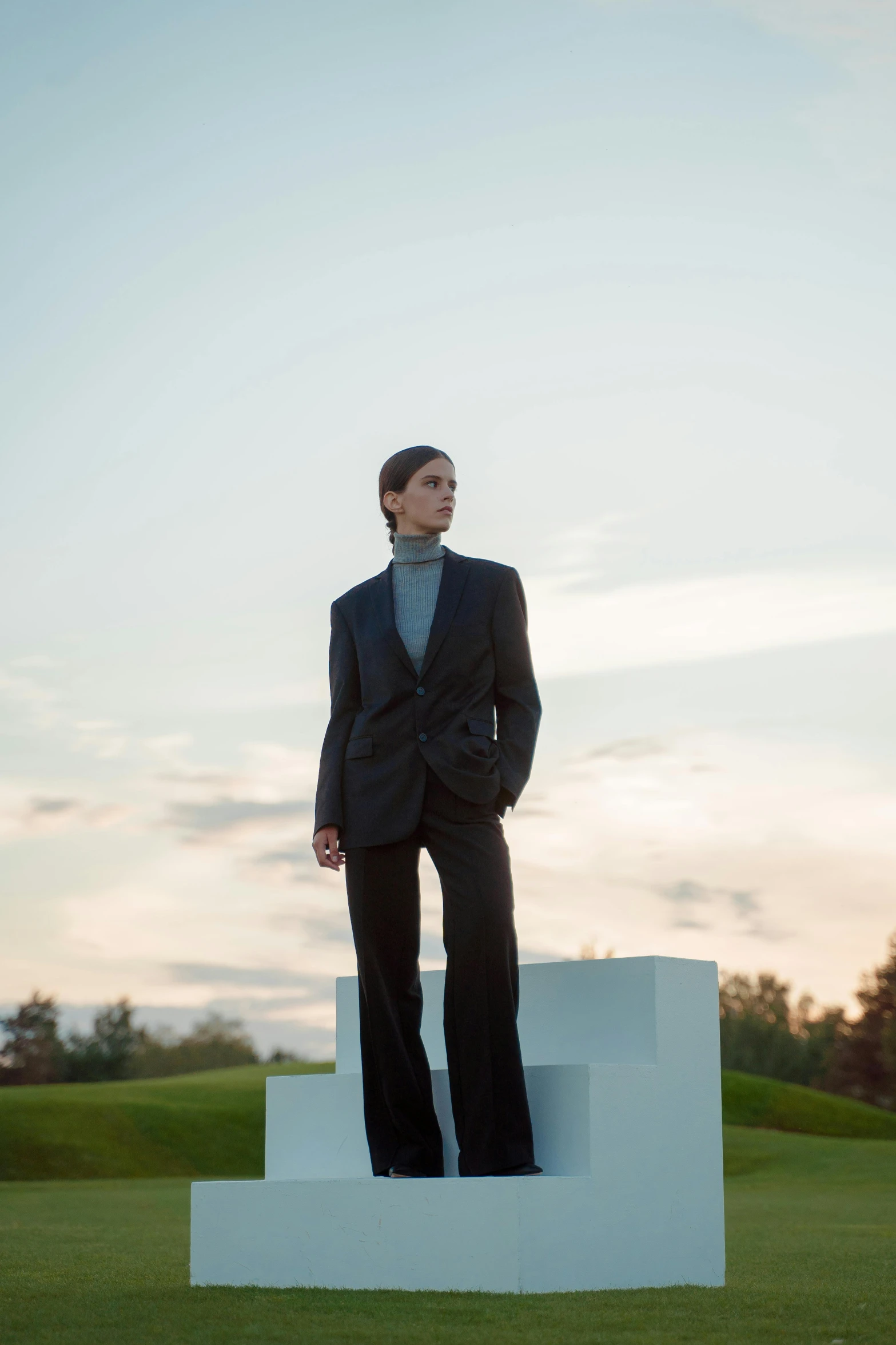 a man wearing a suit and tie standing in front of a piece of paper