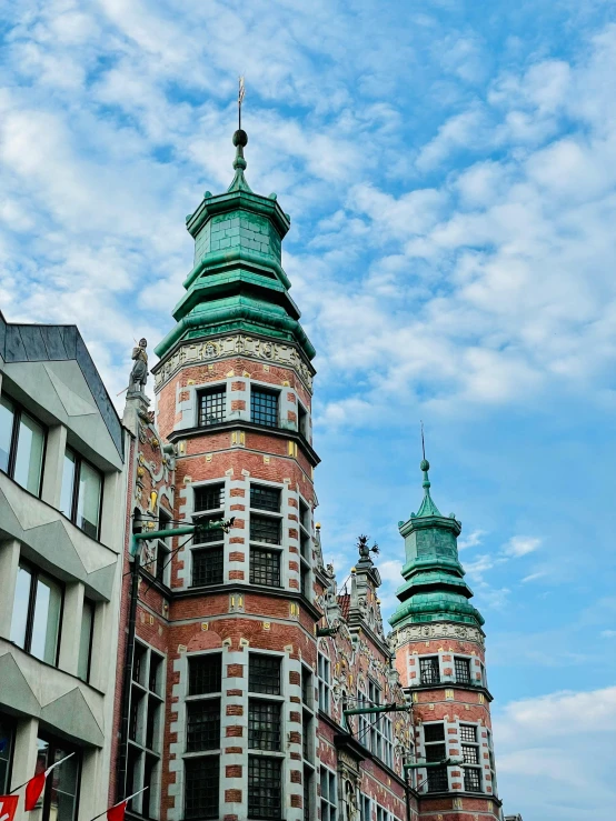 a tall red and green building near buildings