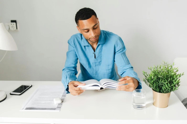 a man at a desk taking notes from a book