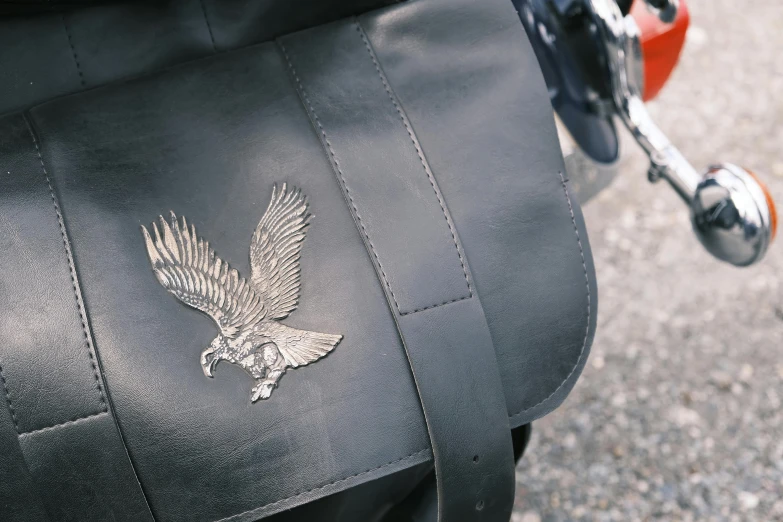 a close up of a black motorcycle seat with a metal eagle logo