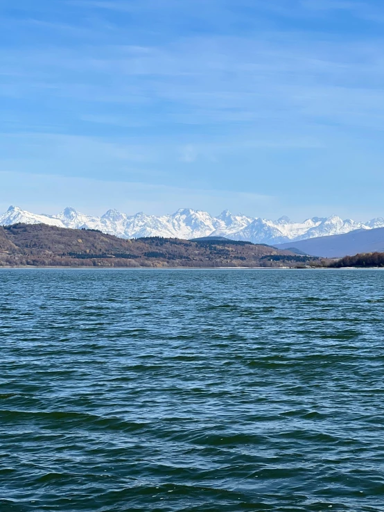 a boat floating on top of a lake surrounded by mountains